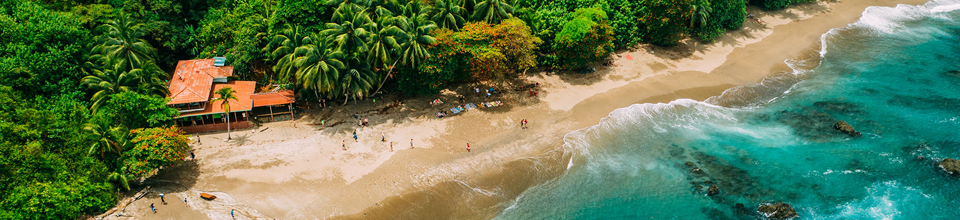 Destinasi wisata tropis dengan pantai berpasir dan laut biru pirus.